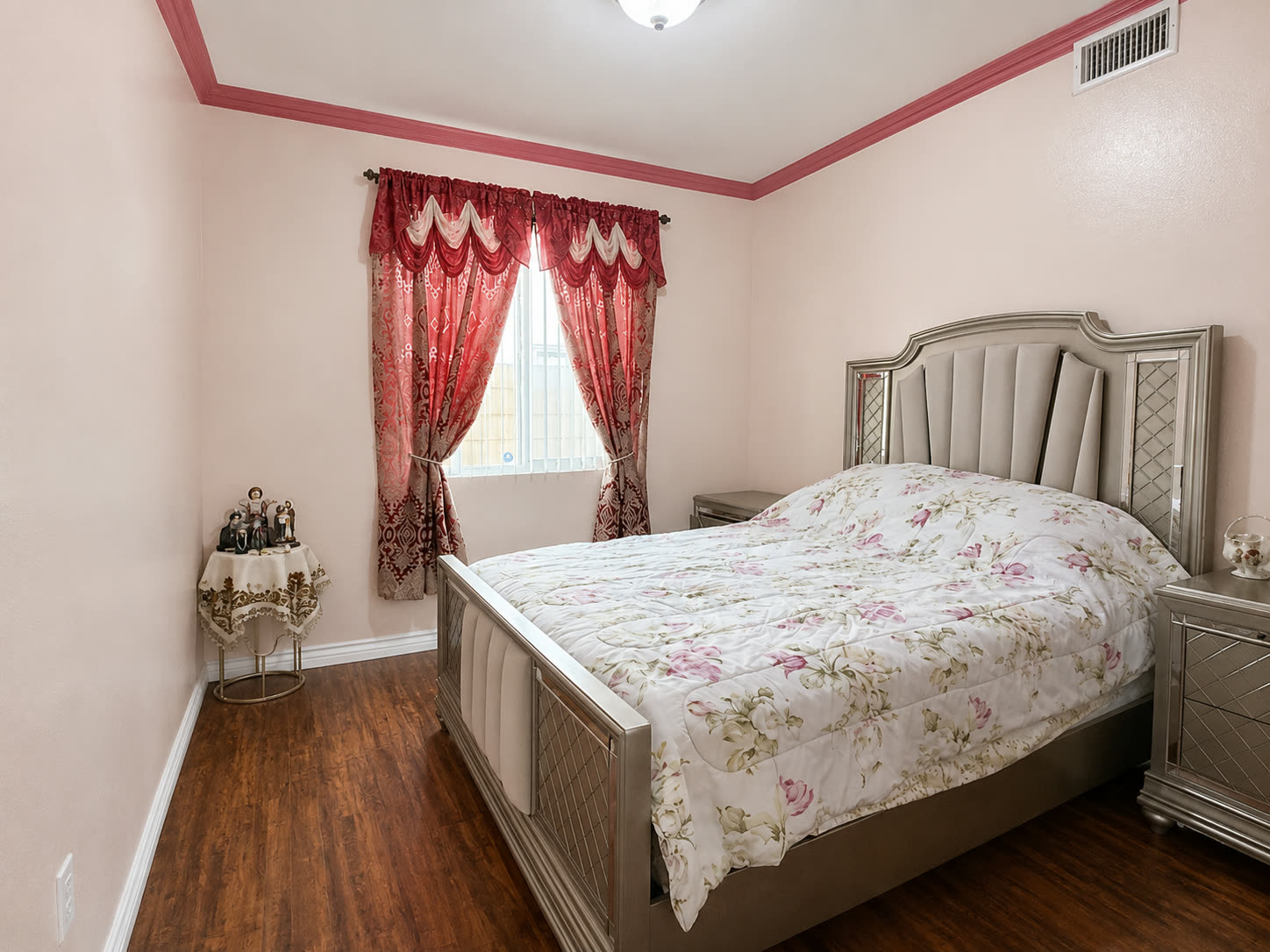 Downstairs bedroom with crown molding and laminate flooring