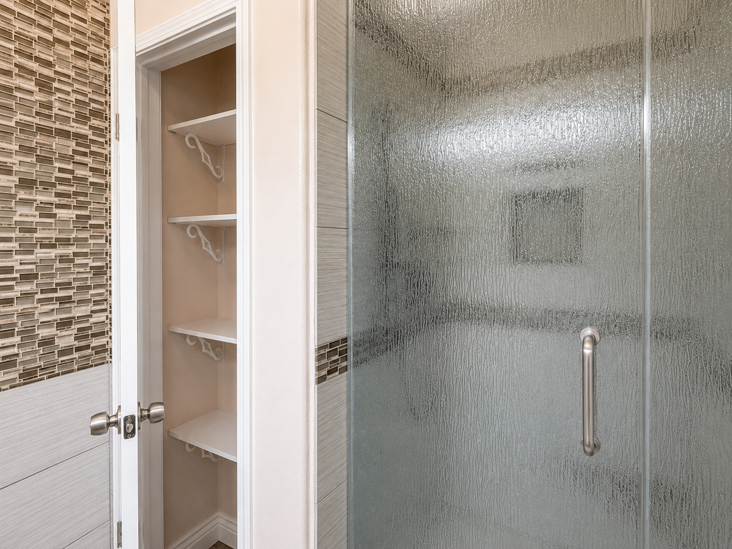 Bath with textured-glass shower and built-in shelving