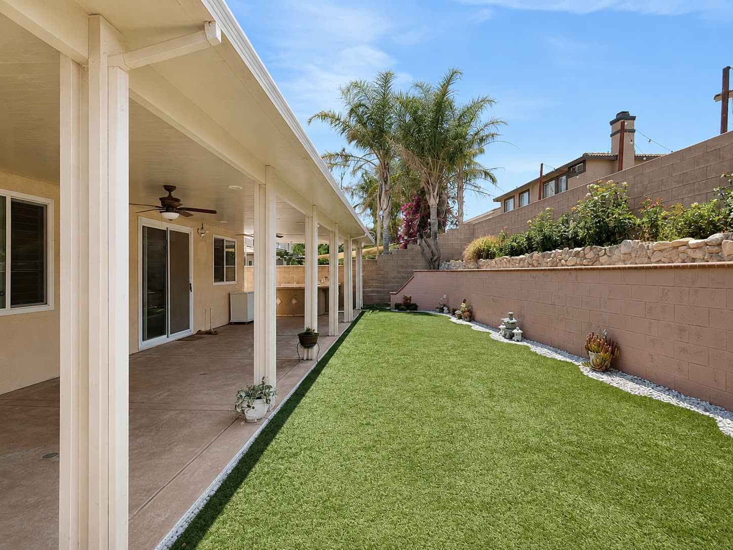 Backyard with low-maintenance turf beside terraced garden beds