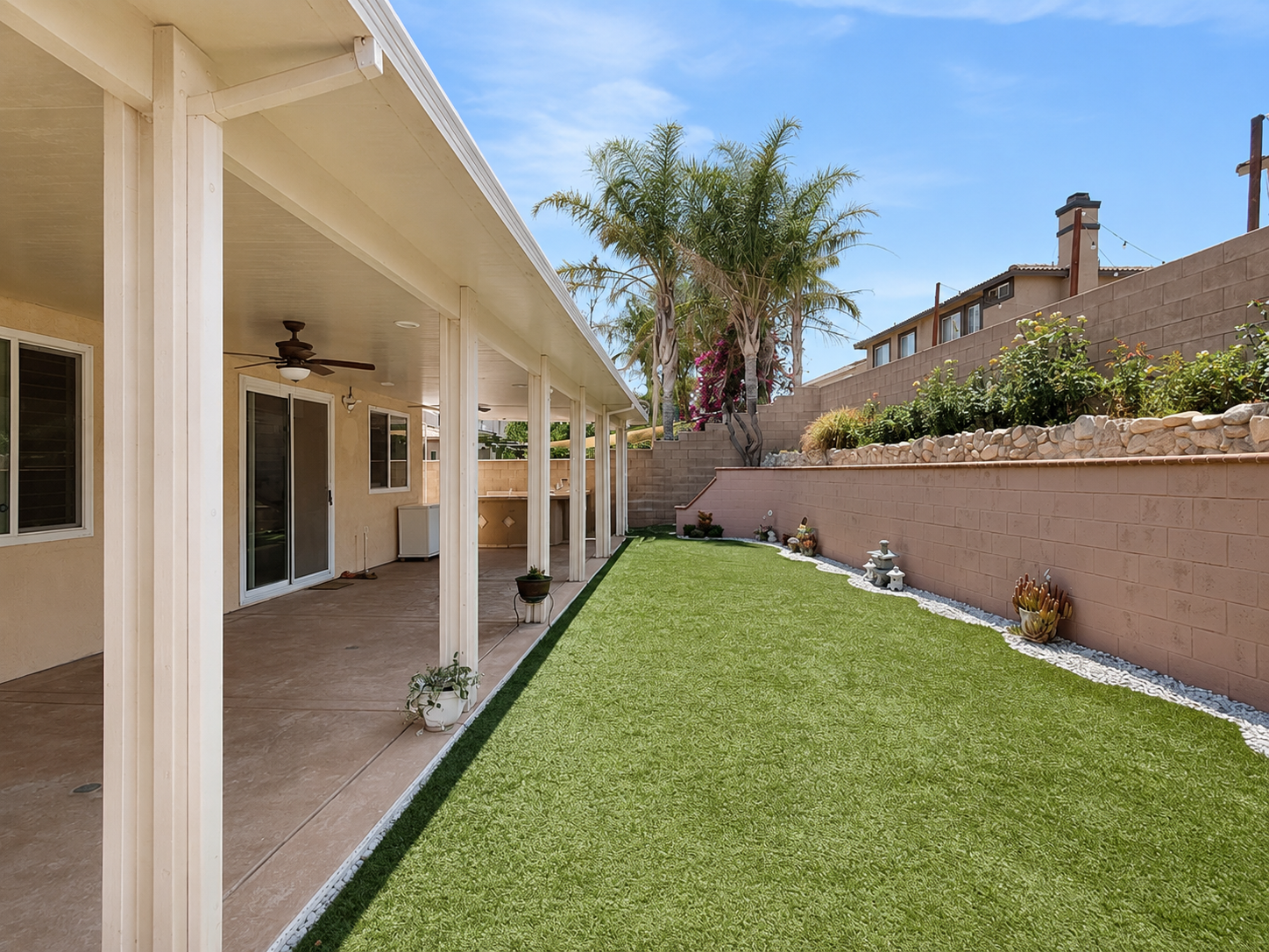 Backyard with low-maintenance turf and white-rock borders