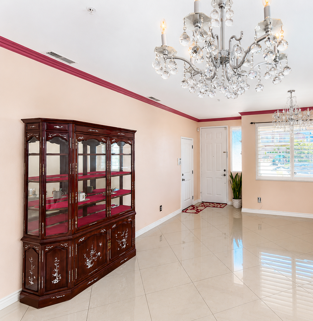 Formal living and dining with polished tile flooring, crown molding, and chandelier lighting