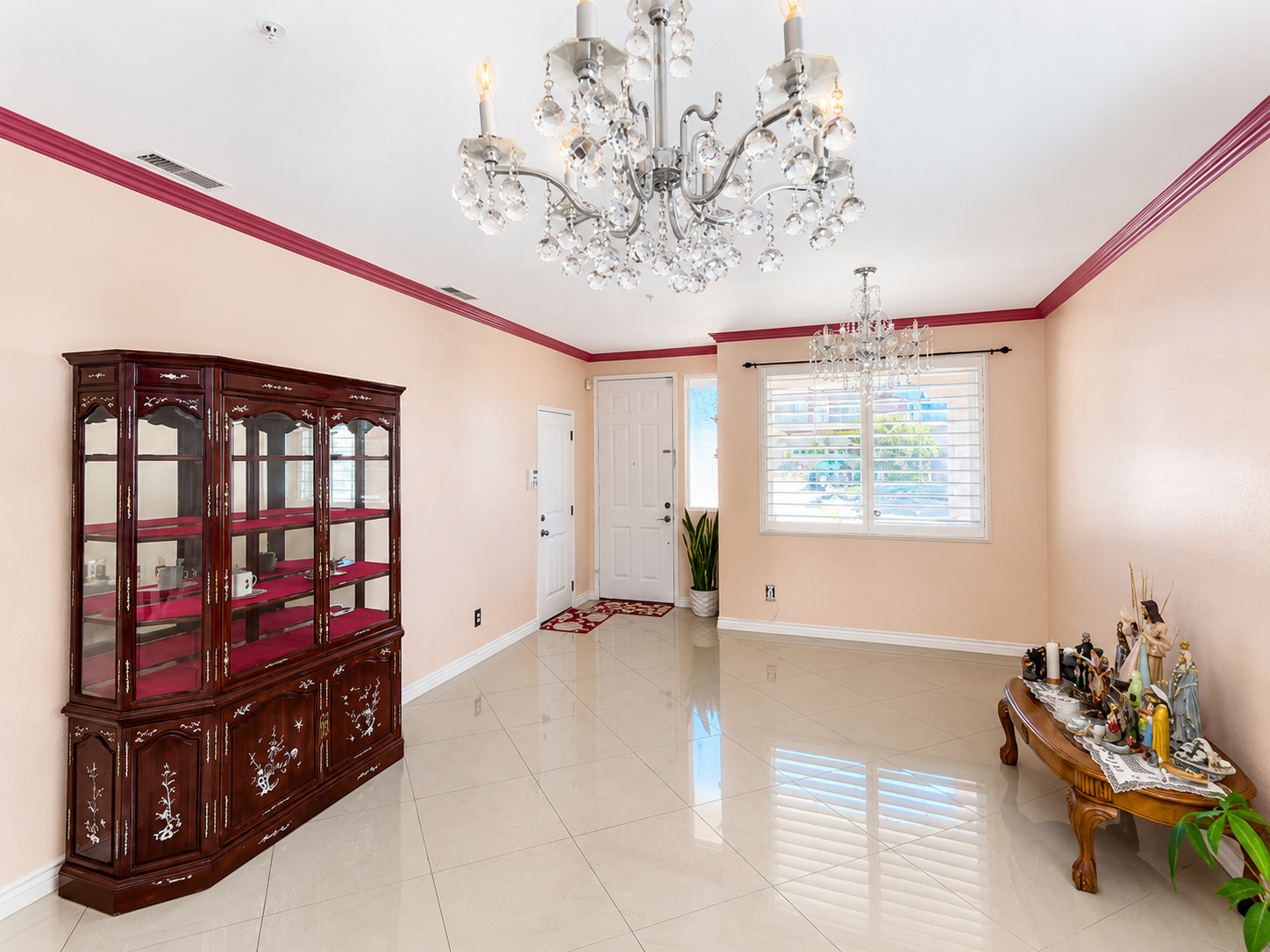 Formal living and dining with polished tile flooring, crown molding, and chandelier lighting