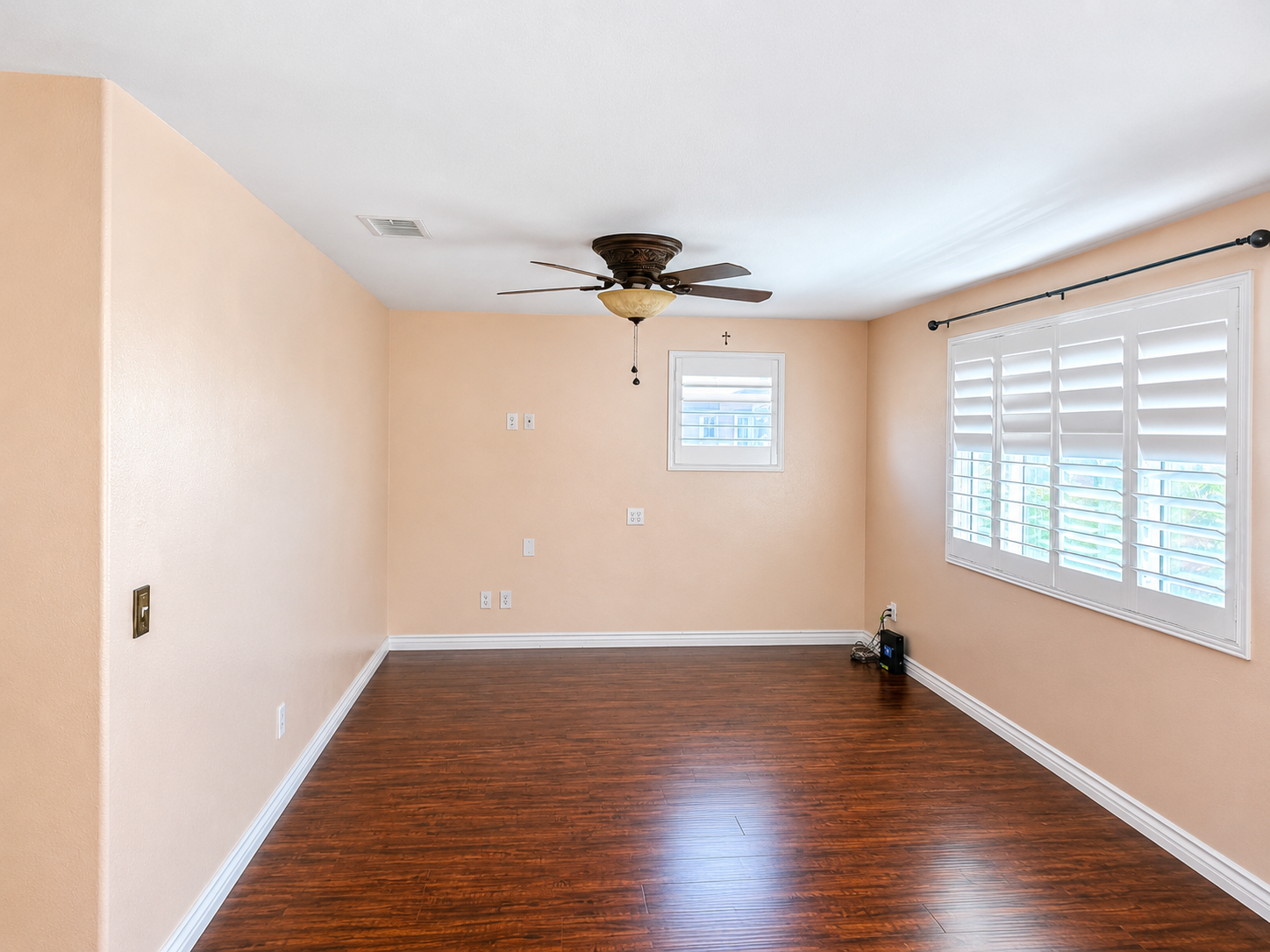 Dining area with laminate flooring, ceiling fan, and plantation-style shutters