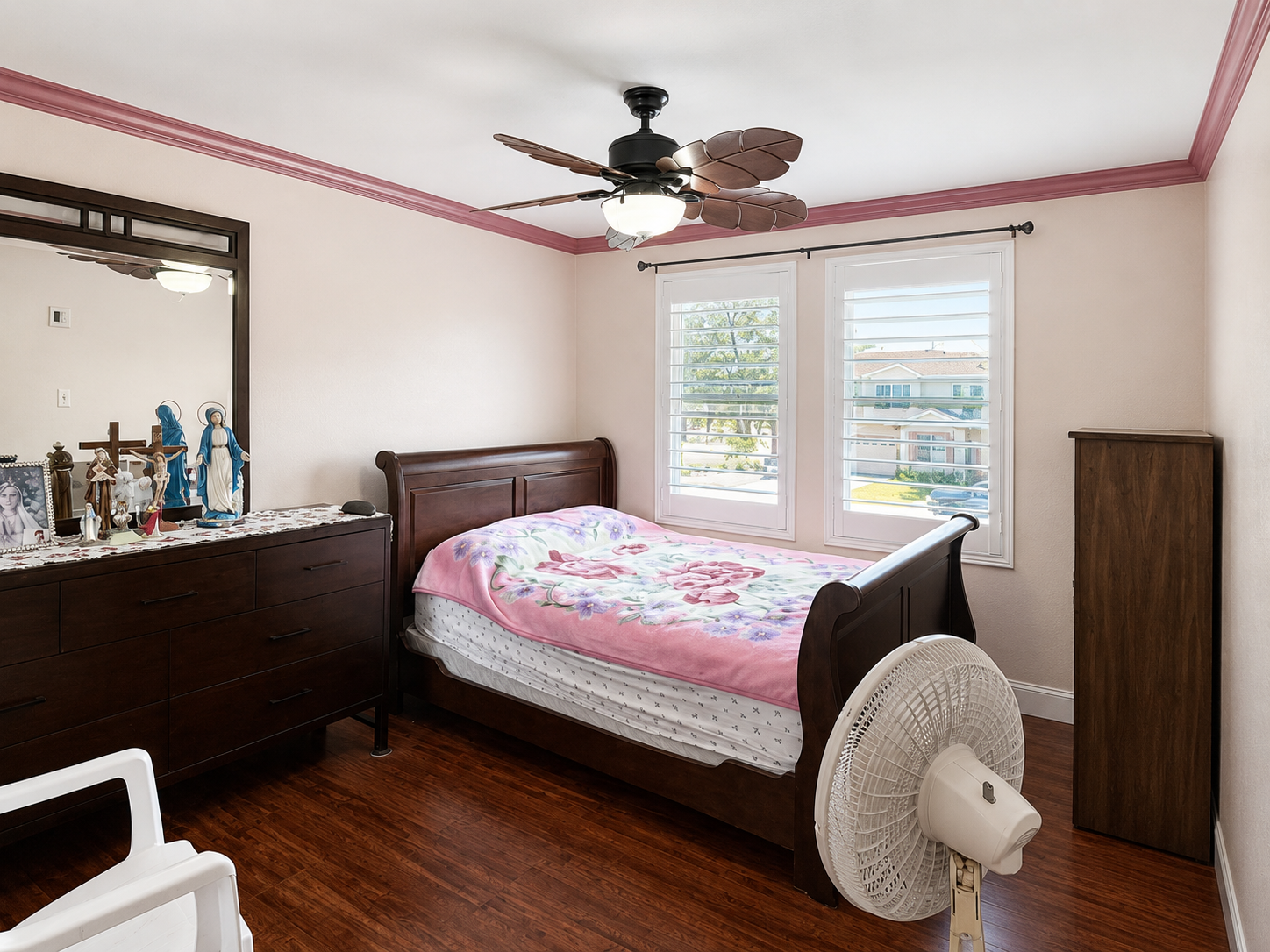 Bedroom with ceiling fan, crown molding, and plantation-style shutters